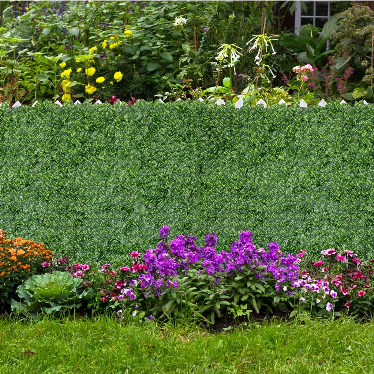 Ein Garten mit einer dichten Hecke aus künstlichem Efeu als Sichtschutz, umgeben von bunten Blumen. Ideal für modernen Sichtschutz im Garten. sträucher als sichtschutz, gräser als sichtschutz, spalierobst als sichtschutz, sichtschutz garten modern.