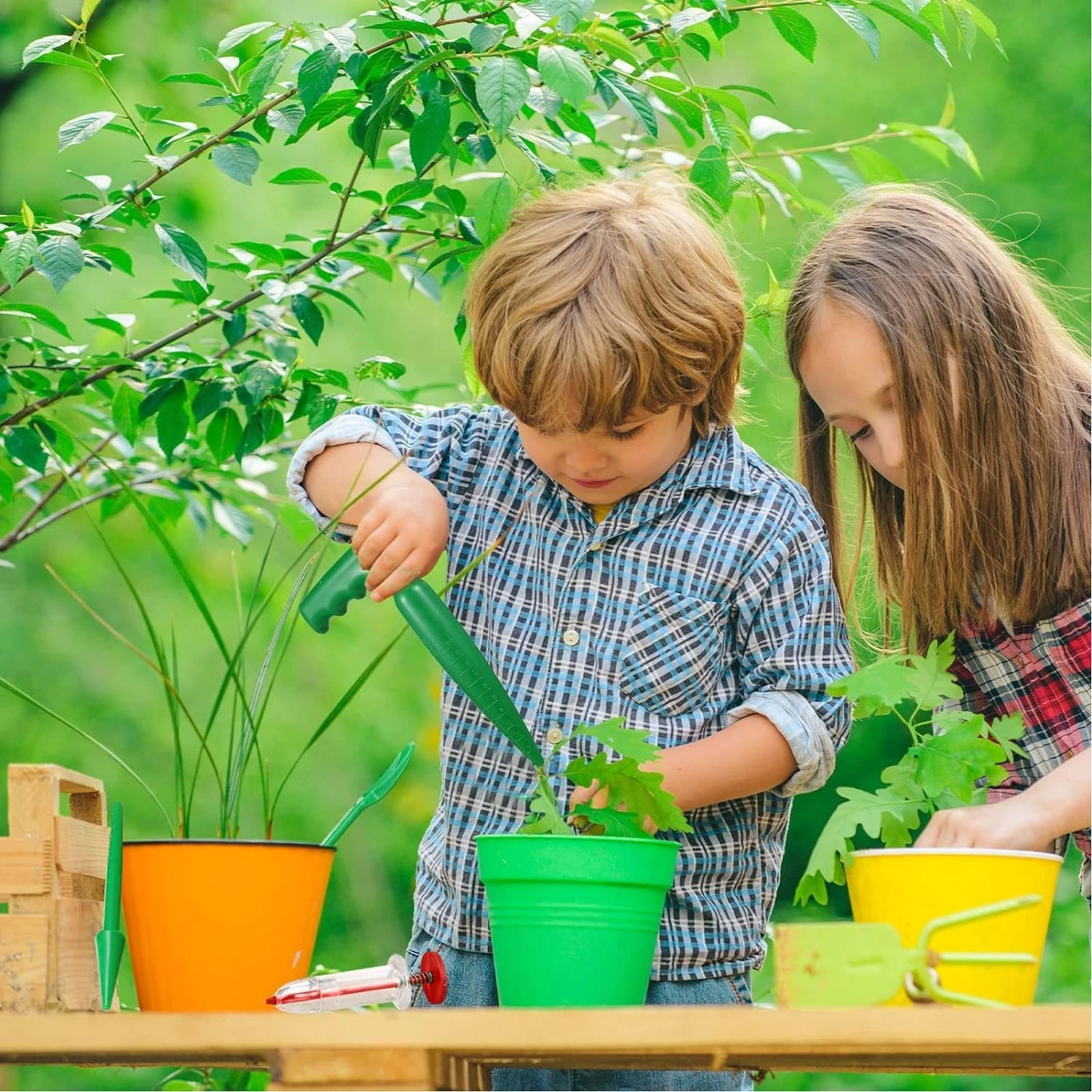 Zwei Kinder pflanzen Blumenzwiebeln in bunten Töpfen im Garten, während sie ein Blumenzwiebel-Pflanzset verwenden. Perfekt für das Pflanzen von Tulpenzwiebeln, Peperoni und Steckzwiebeln.