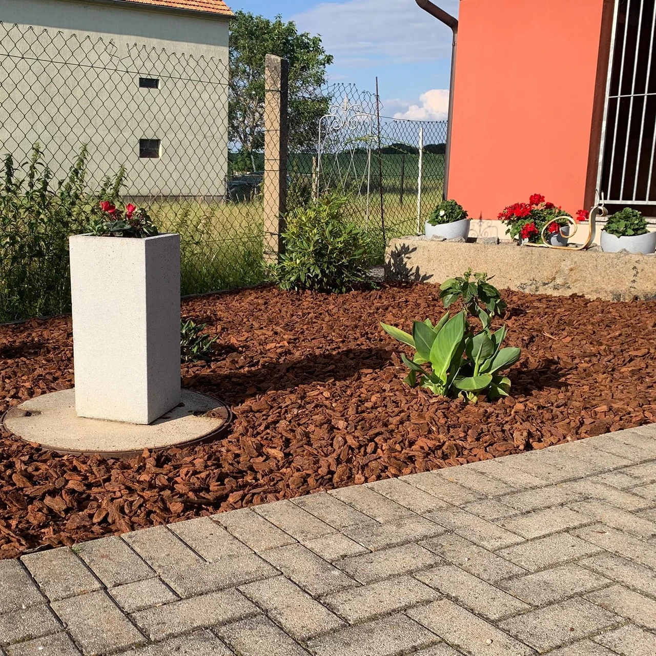 Ein Gartenbeet mit Rindenmulch von Hornbach, der die Feuchtigkeit speichert und Unkraut unterdrückt. Ideal für dekorative und funktionale Bodenabdeckung. Perfekt für Gartenprojekte mit Hornbach Rindenmulch oder Bauhaus Rindenmulch.