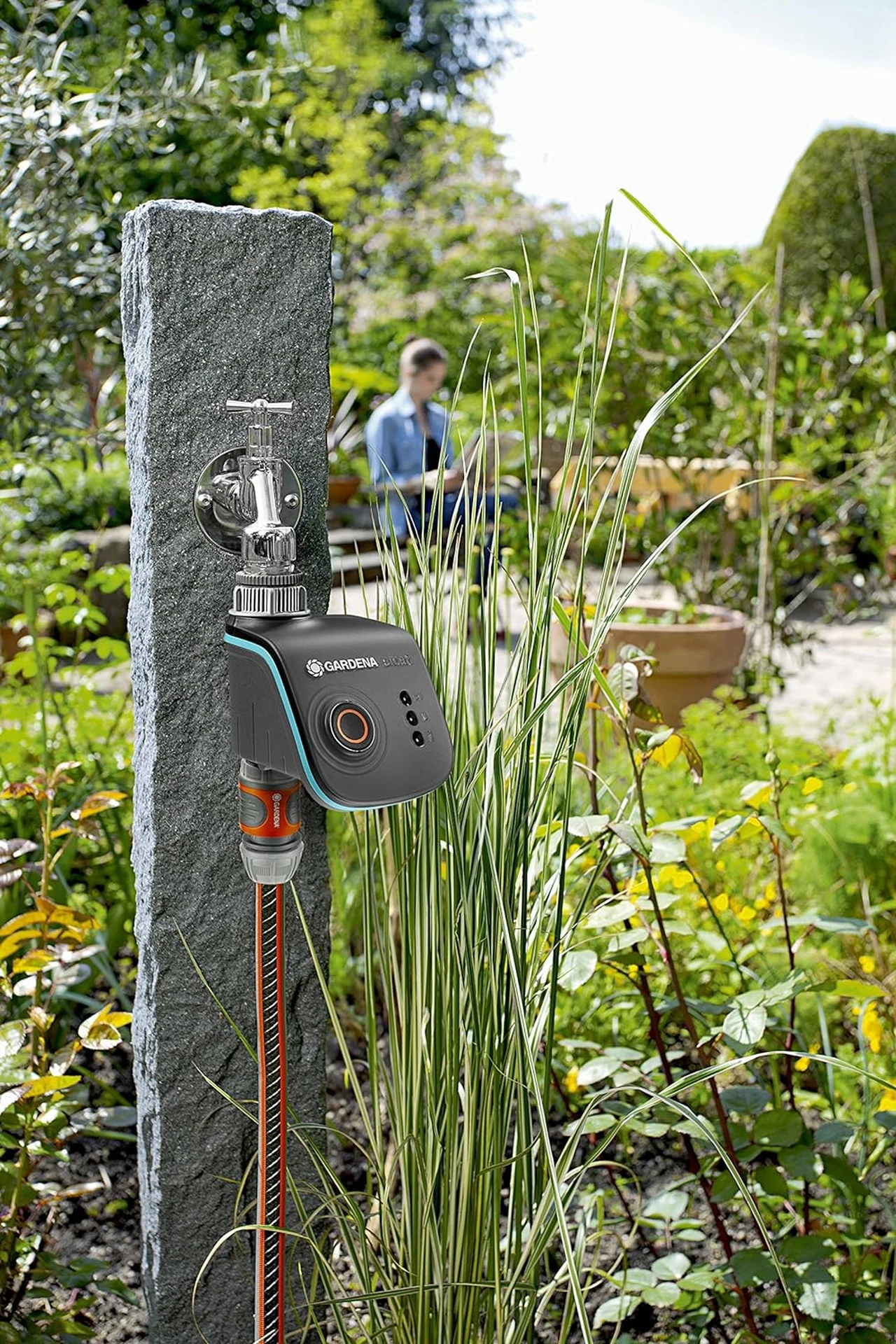Gardena Bewässerungscomputer an einem Wasserhahn im Garten installiert, um die automatische Bewässerung zu demonstrieren